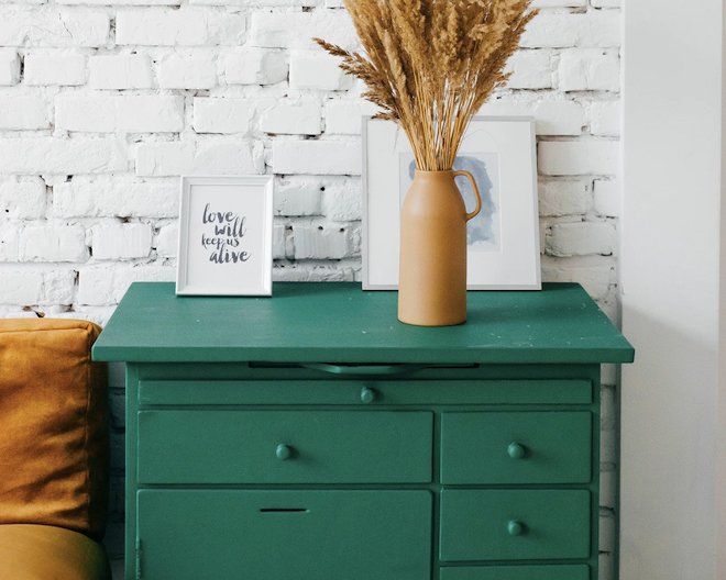 Image of bedside table with lamp and picture on top.